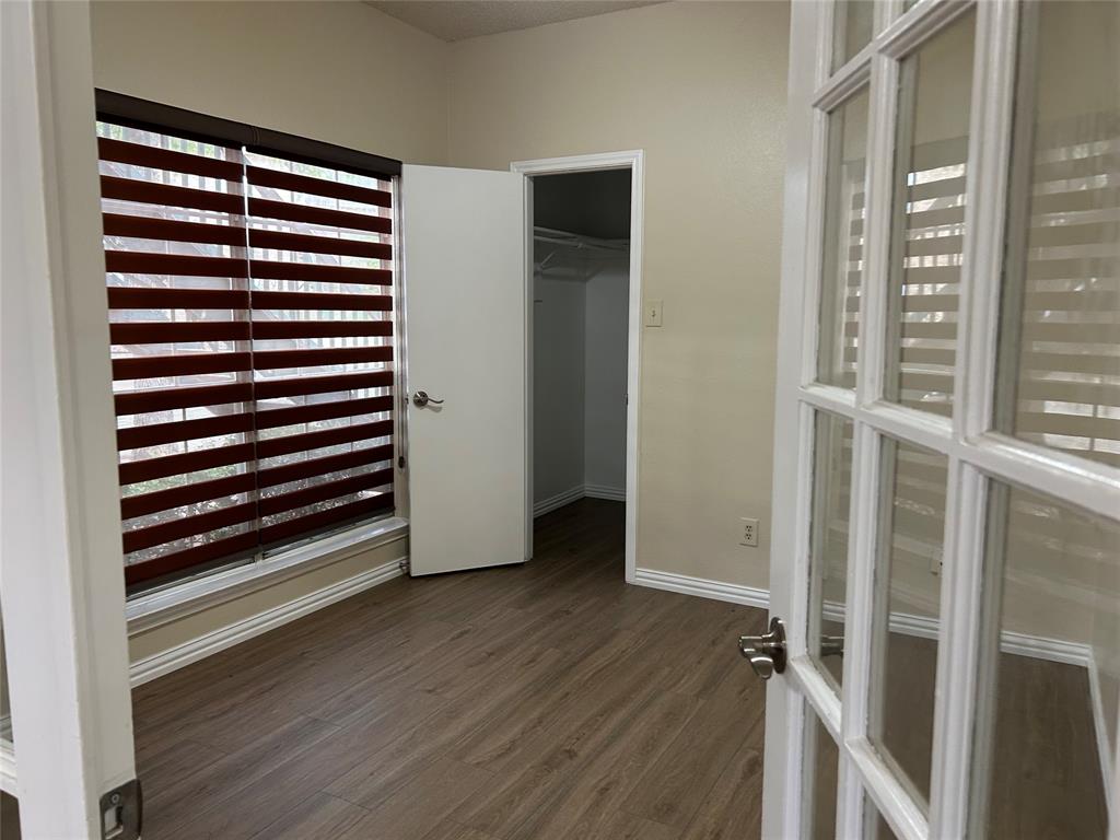 4101 Esters Road, Unit 101 Irving, TX 75038 - Photo 5 of 11 an empty room with wooden floor and windows