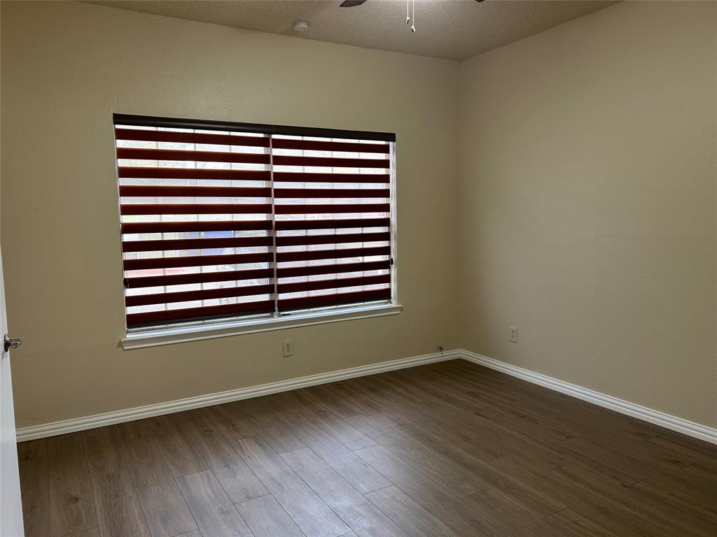 4101 Esters Road, Unit 101 Irving, TX 75038 - Photo 6 of 11 an empty room with wooden floor and a window