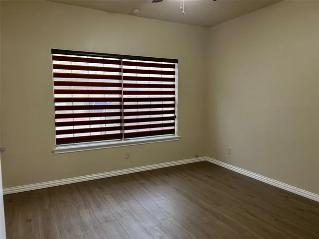 an empty room with wooden floor and a window