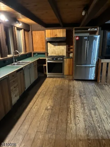 a kitchen with granite countertop a refrigerator and a sink