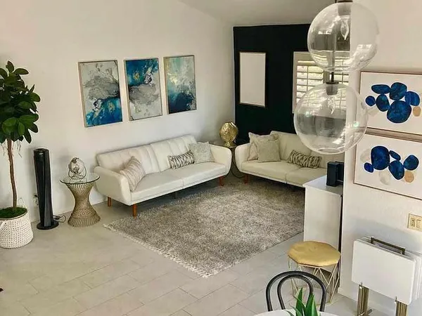 a living room with furniture and a chandelier