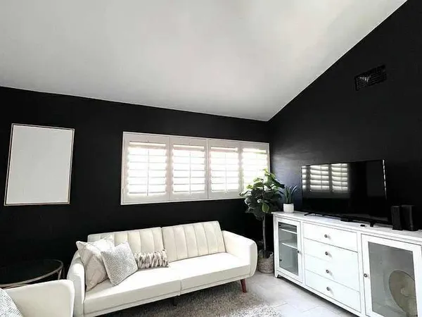 a living room with furniture flat screen tv and window