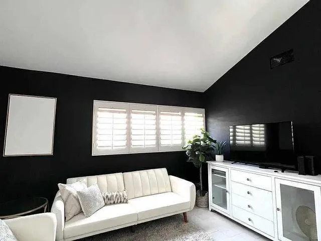 a living room with furniture flat screen tv and window