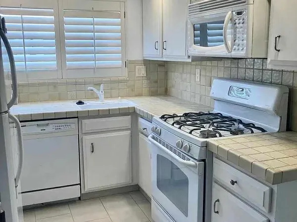 a kitchen with cabinets appliances and a sink