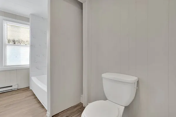 a white toilet sitting next to a window