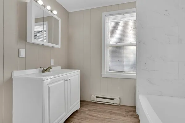 a bathroom with a sink a vanity and a bathtub