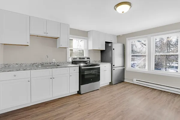 a kitchen with granite countertop white cabinets and white appliances