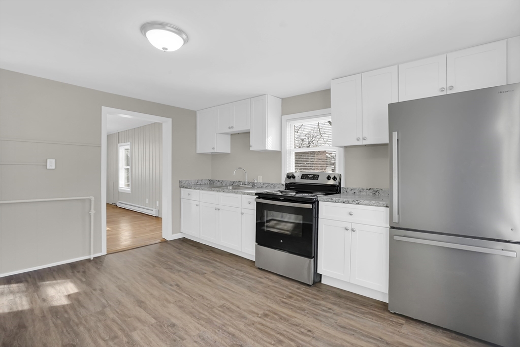 21 Depot Street Chicopee, MA 01013 - Photo 25 of 31 a kitchen with granite countertop a refrigerator stove and wooden floor