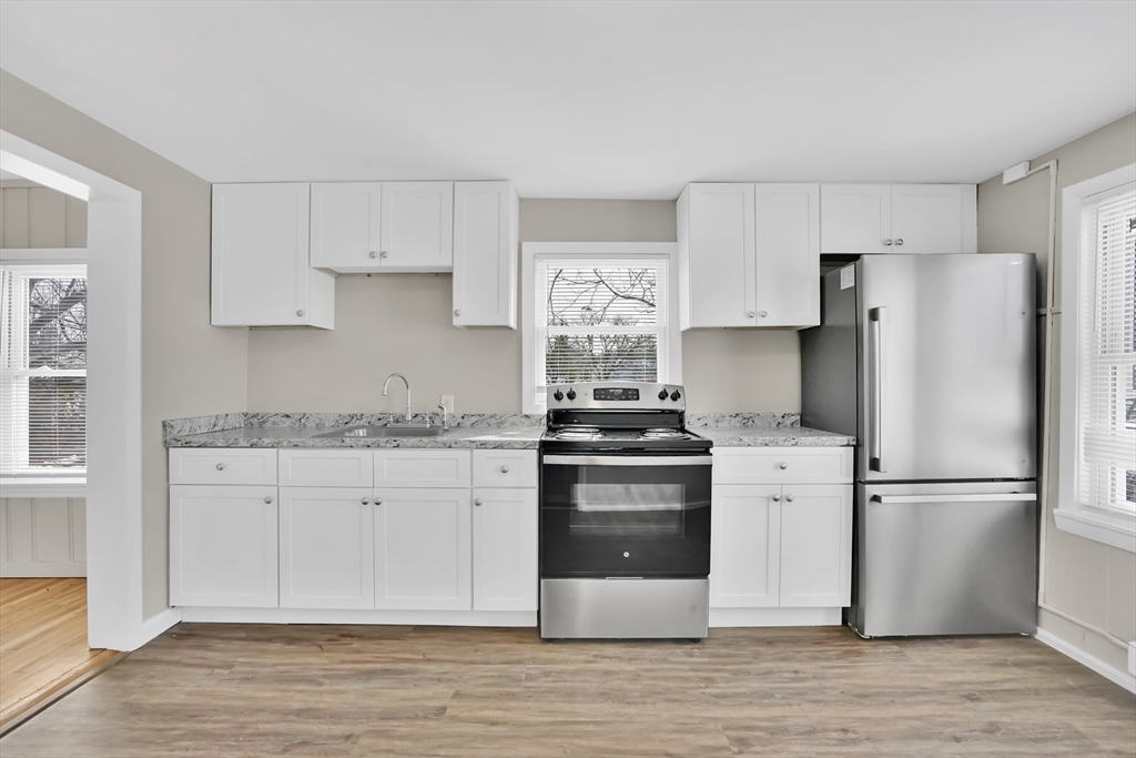 21 Depot Street Chicopee, MA 01013 - Photo 27 of 31 a kitchen with granite countertop a refrigerator stove and white cabinets
