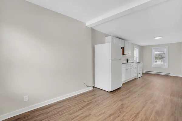 a view of a kitchen with wooden floor and electronic appliances