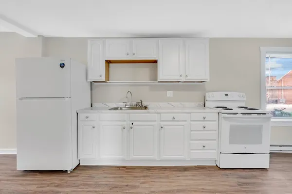 a kitchen with granite countertop white cabinets and white appliances