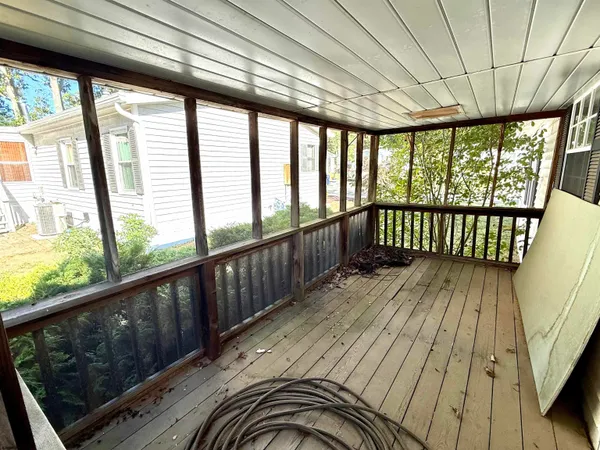 a view of a porch with wooden floor and furniture