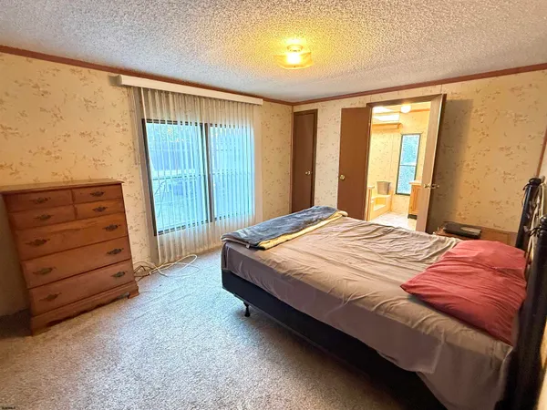 a bed sitting in a spacious bedroom next to a window