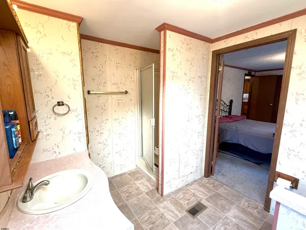 a en suite bathroom with a granite countertop sink and a mirror