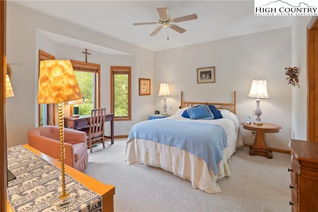 a spacious bedroom with a bed a couch and a larger window