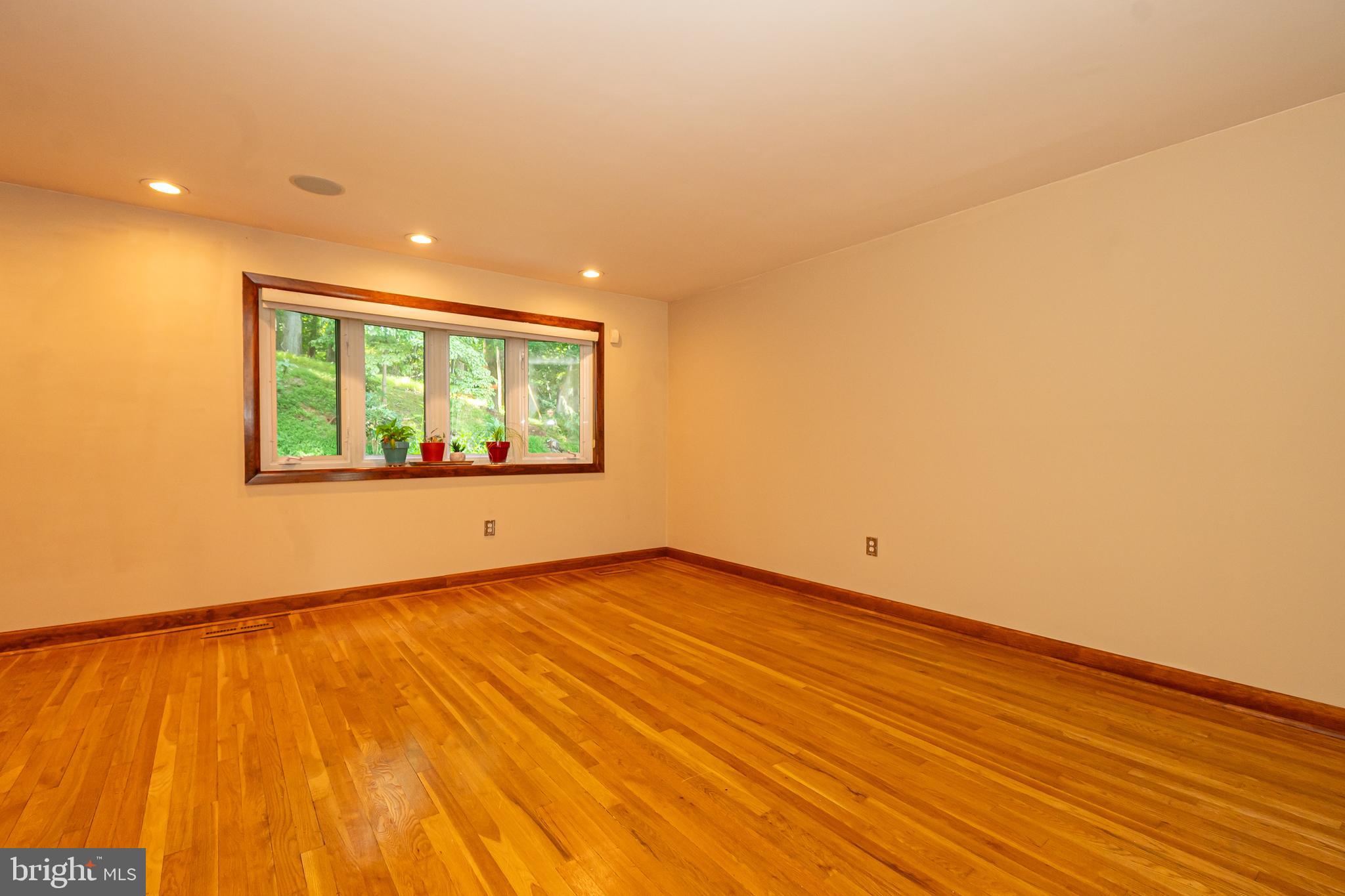 4523 Hawksbury Road Baltimore, MD 21208 - Photo 14 of 35 a view of an empty room with a window and wooden floor
