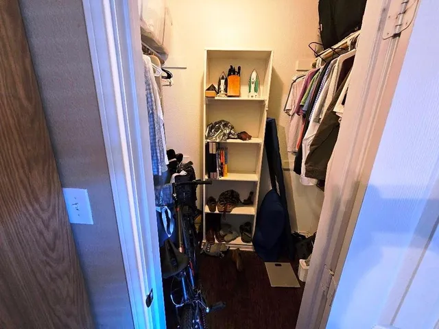 a view of walk in closet with clothes and shoes