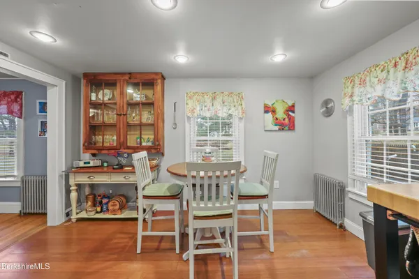 a view of a dining room with furniture a chandelier and wooden floor