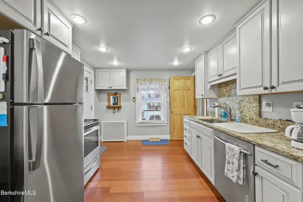 a kitchen with stainless steel appliances granite countertop a refrigerator and a sink