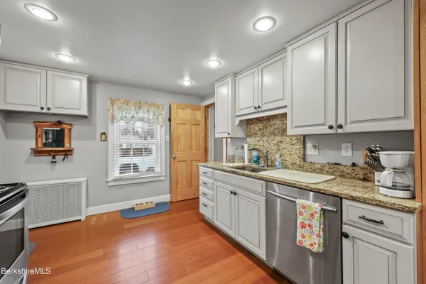 a kitchen with stainless steel appliances granite countertop a sink stove and cabinets