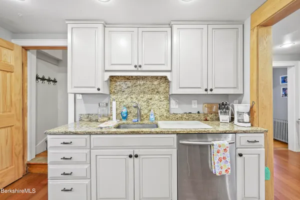 a kitchen with stainless steel appliances granite countertop a sink and a stove with white countertops