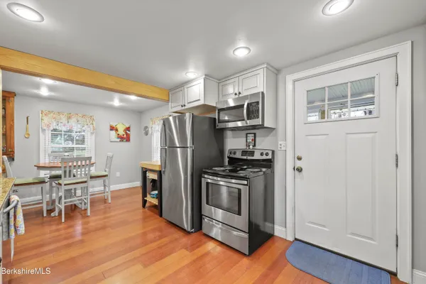 a kitchen with stainless steel appliances a refrigerator stove and wooden floor