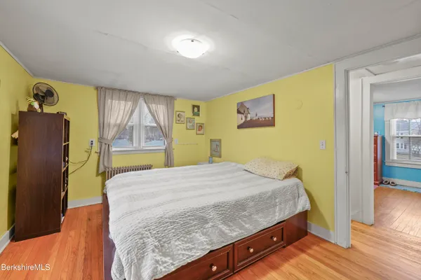 a bedroom with a bed and wooden floor