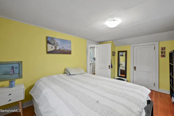 a bedroom with a bed and a painting on the wall