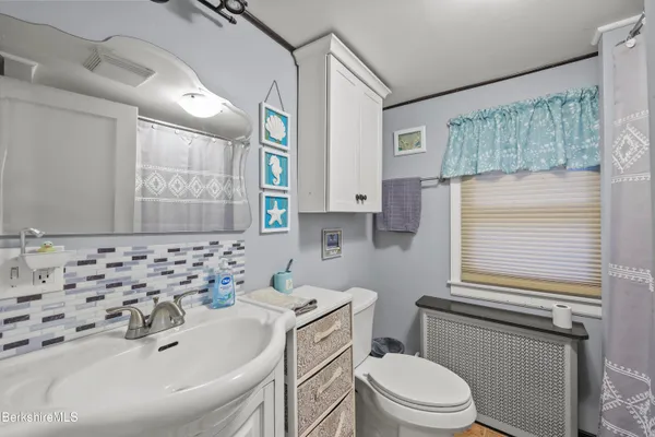 a bathroom with a sink toilet vanity and window