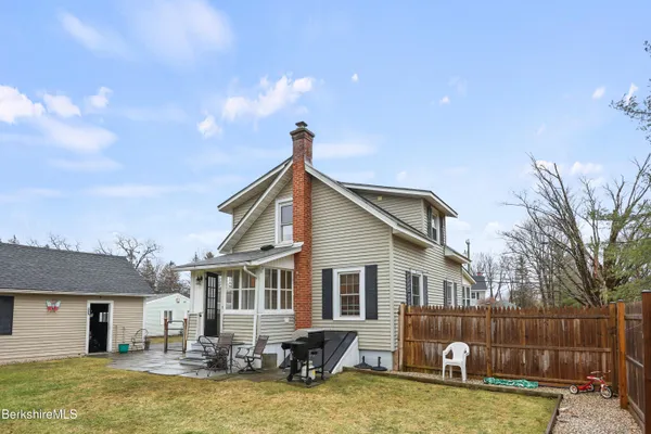 a backyard of a house with barbeque oven table and chairs