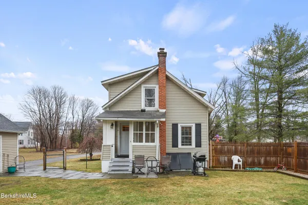 a view of a house with a yard patio and fire pit