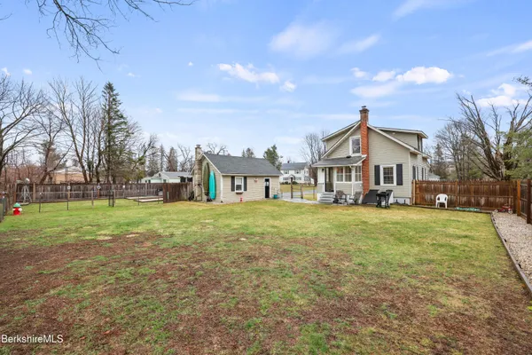 a view of a house with a big yard and large trees