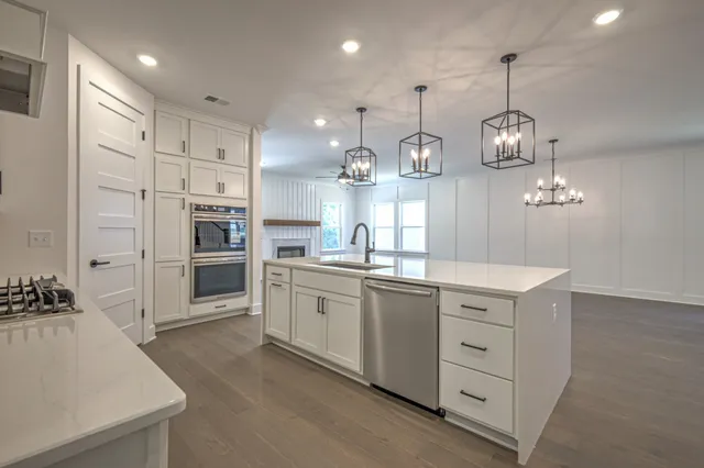 a large kitchen with stainless steel appliances granite countertop a lot of counter space and wooden floor