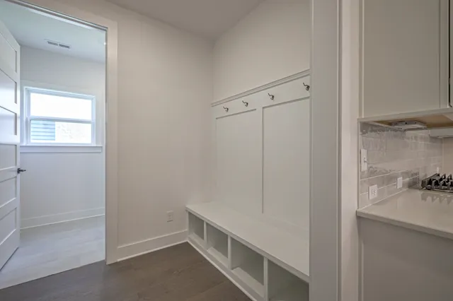 an empty room with wooden floor a ceiling fan and windows