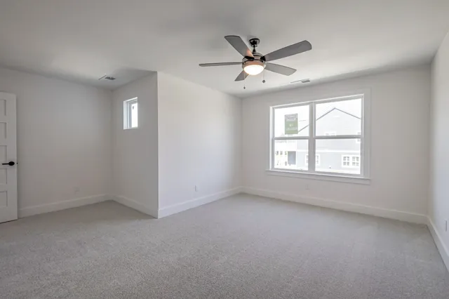 an empty room with a window and a fan