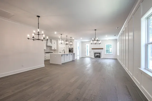a view of a kitchen with a dishwasher a kitchen island wooden floor and a window
