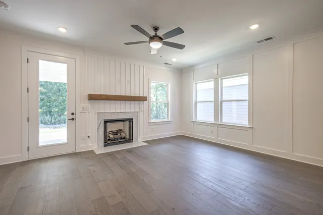 a view of a livingroom with a fireplace window and wooden floor