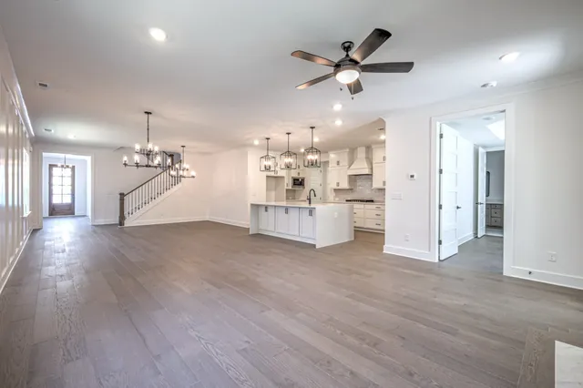 a view of a kitchen with wooden floor and a ceiling fan