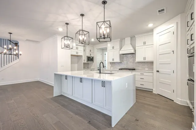 a open kitchen with white cabinets and stainless steel appliances