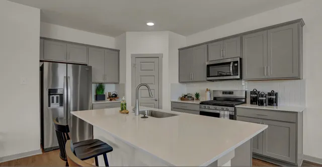 a kitchen with stainless steel appliances a microwave sink and cabinets