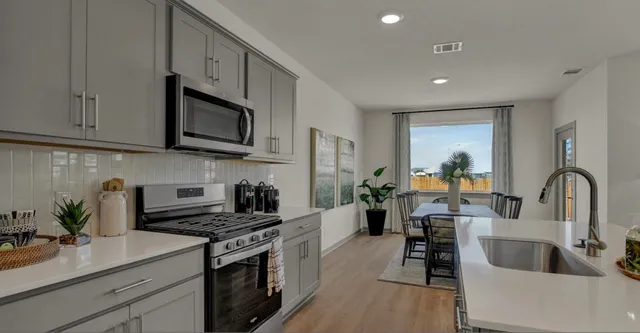 a kitchen with stainless steel appliances granite countertop a sink stove and cabinets