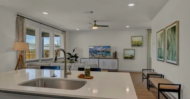 a kitchen with a sink a chandelier and living room view