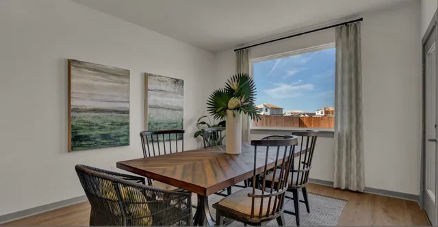 a dining room with furniture a floor to ceiling window and wooden floor