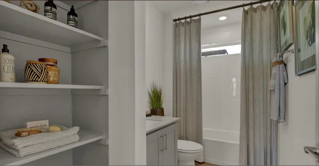 a bathroom with a shower a toilet and a sink