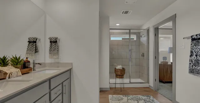a bathroom with a shower sink and mirror