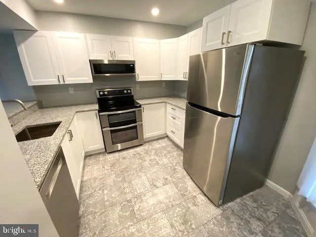 a kitchen with stainless steel appliances a refrigerator and a stove