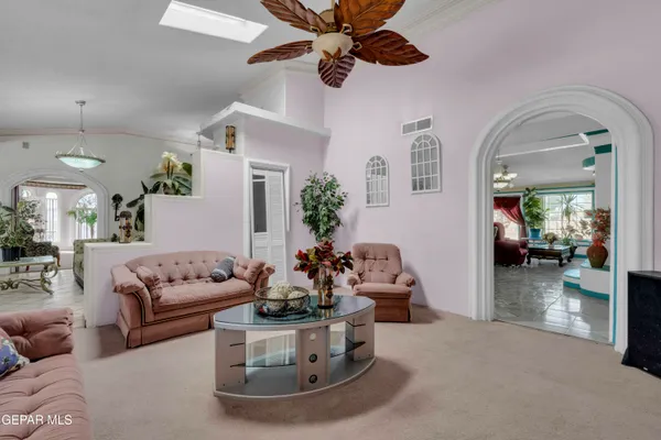 a living room with furniture and a chandelier