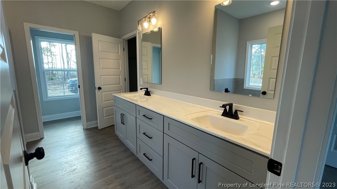 7697 Rufus Johnson Road Fayetteville, NC 28306 - Photo 11 of 16 a bathroom with double sink and two mirror