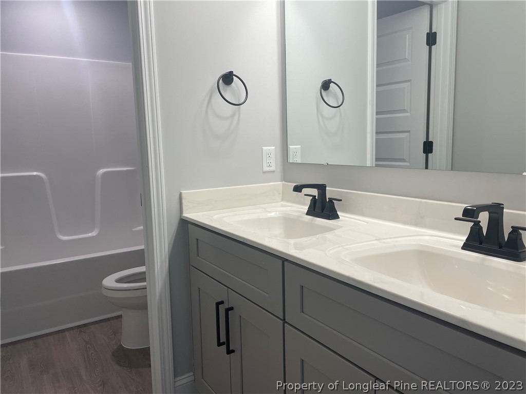 7697 Rufus Johnson Road Fayetteville, NC 28306 - Photo 14 of 16 a bathroom with a sink a toilet and a mirror