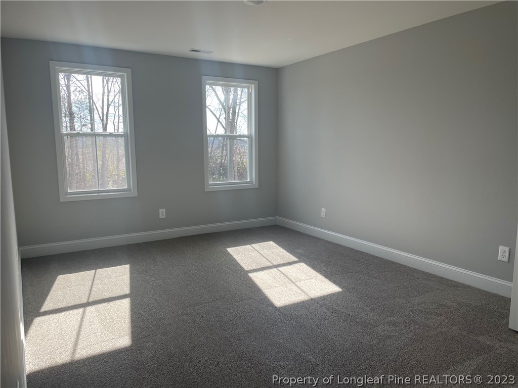 7697 Rufus Johnson Road Fayetteville, NC 28306 - Photo 15 of 16 an empty room with wooden floor and windows